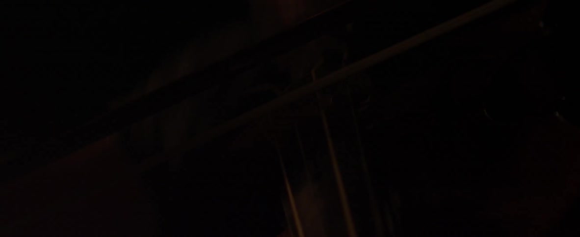 Dim outline of a pole or fence at night