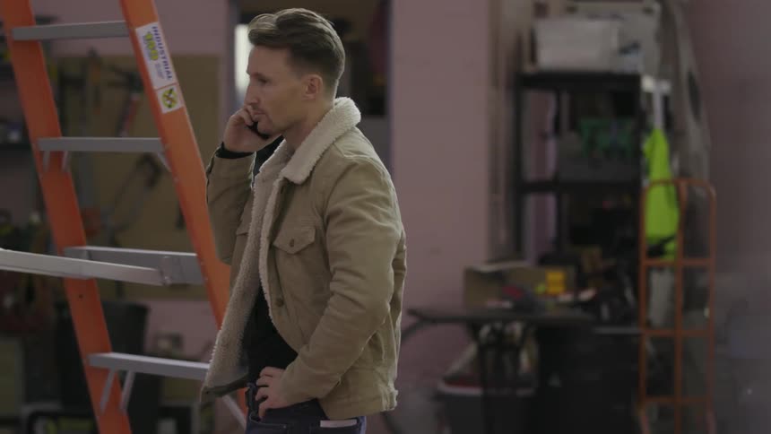 A man is talking on his phone as other people work
