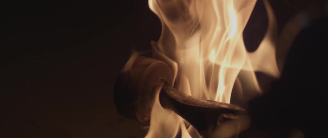 A skateboard wheel is spinning upside down as the board is on fire