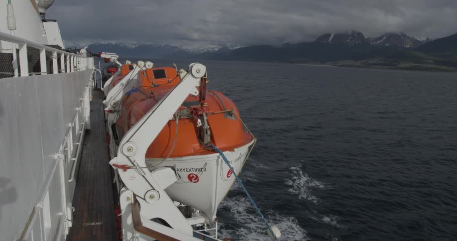 Lifeboats alongside a moving cruise ship