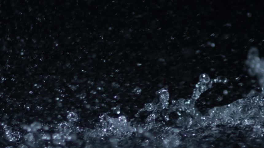Water splashes up and bubbles in the darkness
