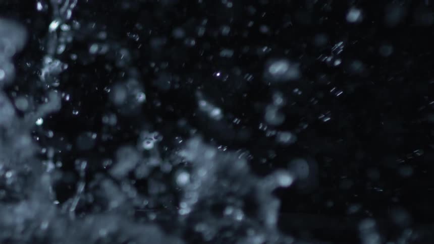 Water splashes up and bubbles in the dark