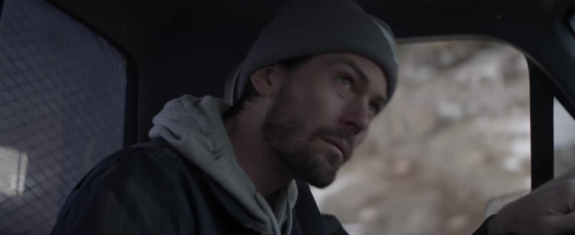 A man is driving in a car and is searching for something