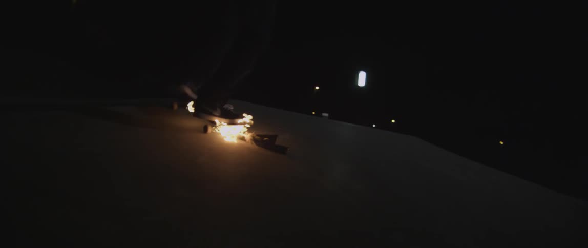 A skateboarder rides on a burning skateboard