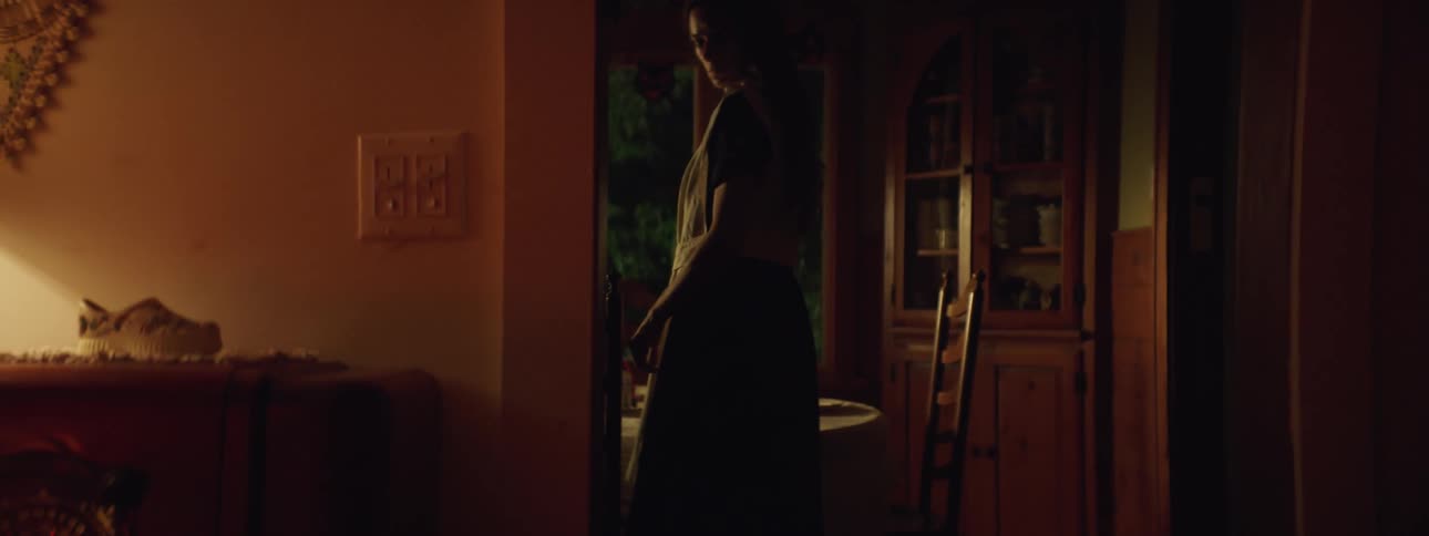 A woman setting a dinner table looks back at a radio