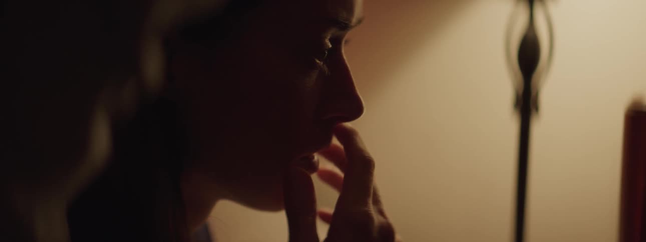 A woman is looking at something off screen and is shocked by what she sees