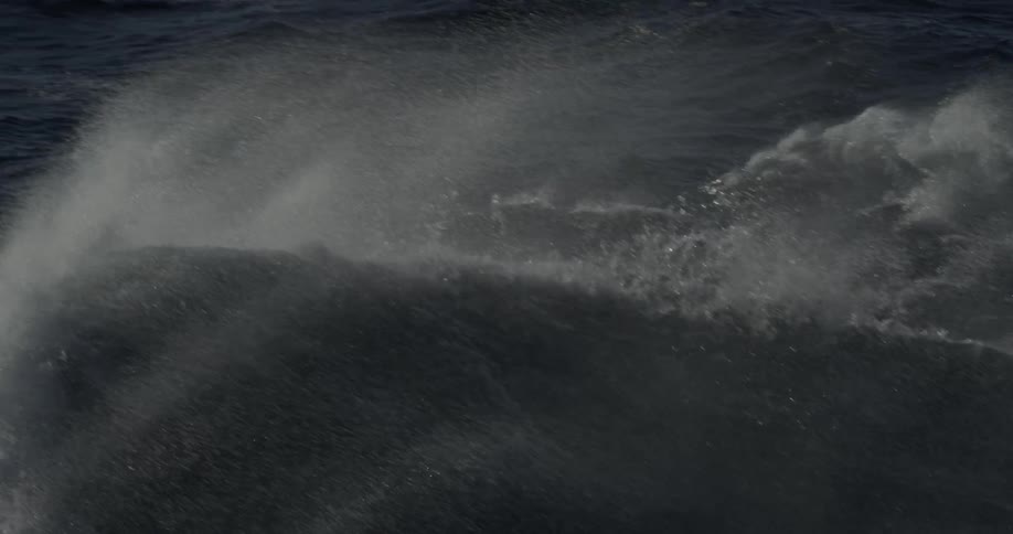 Moody ocean waves splash and break in the wind