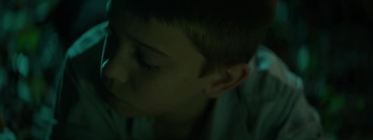 A boy is looking around in a dark room
