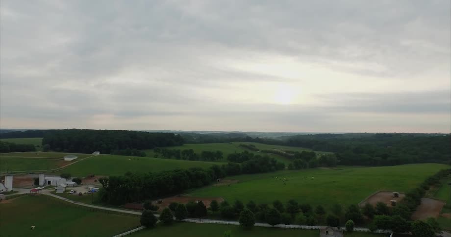 The fields below are green leading towards a farm