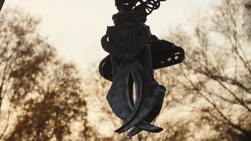 Close up of a metal hook with trees in the background