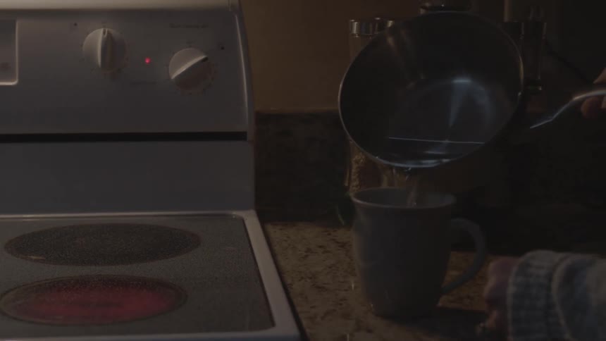 A person pouring liquid into a mug