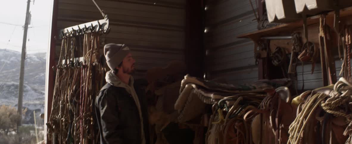 Man puts large piece of cloth on a pile in a barn