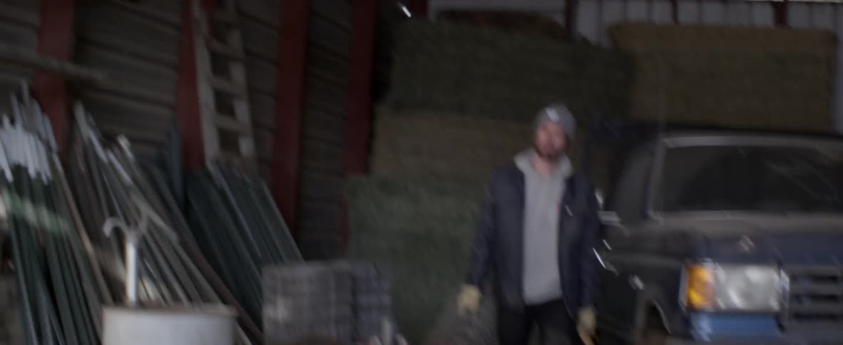 Man removes a roll of barbed wire from a truck