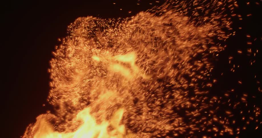 Fire burns brightly and sparks fly up