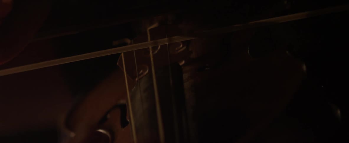 A bow is drawn across violin strings