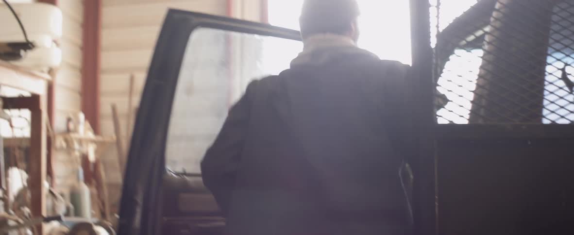 A man walks over and gets into his truck