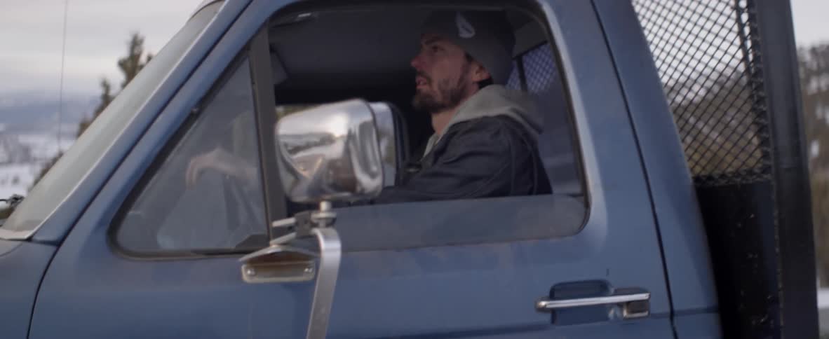 A man gets in and drives away in a flatbed truck