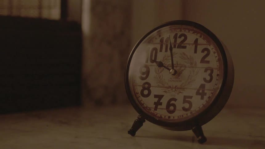 An old desktop clock sits on a counter top