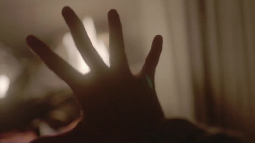 A hand is raised near a fire