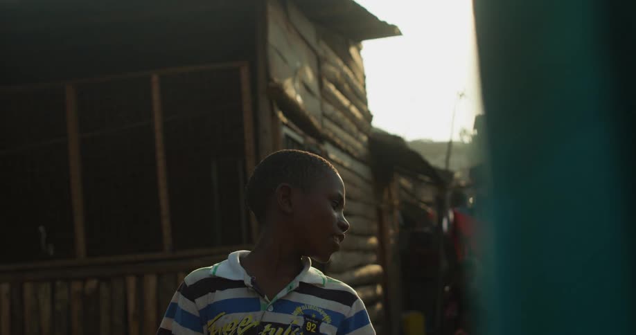 Young child in a striped shirt turns his head while talking