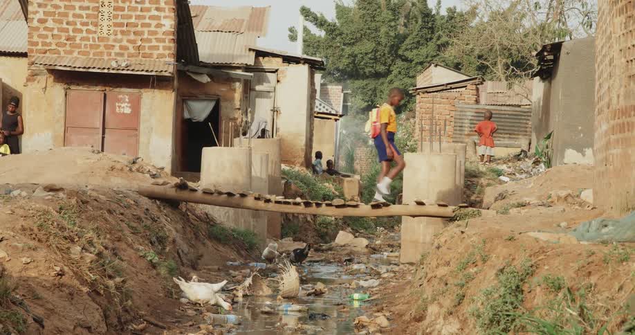 A boy walks over a small wooden bridge