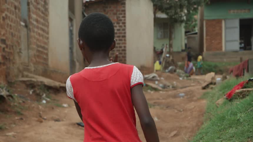 A child walks outside in a town on a summer day