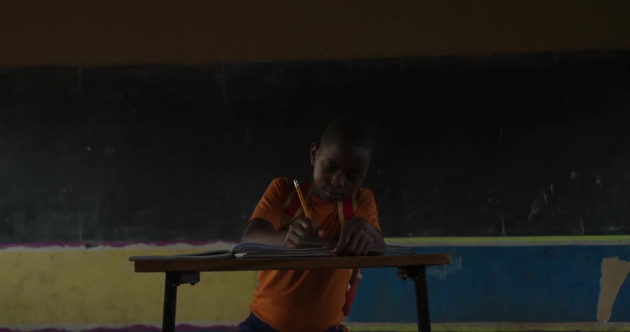 Child sits at a desk writing in a notebook