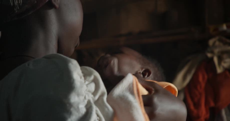 A woman is rocking a baby in her arms