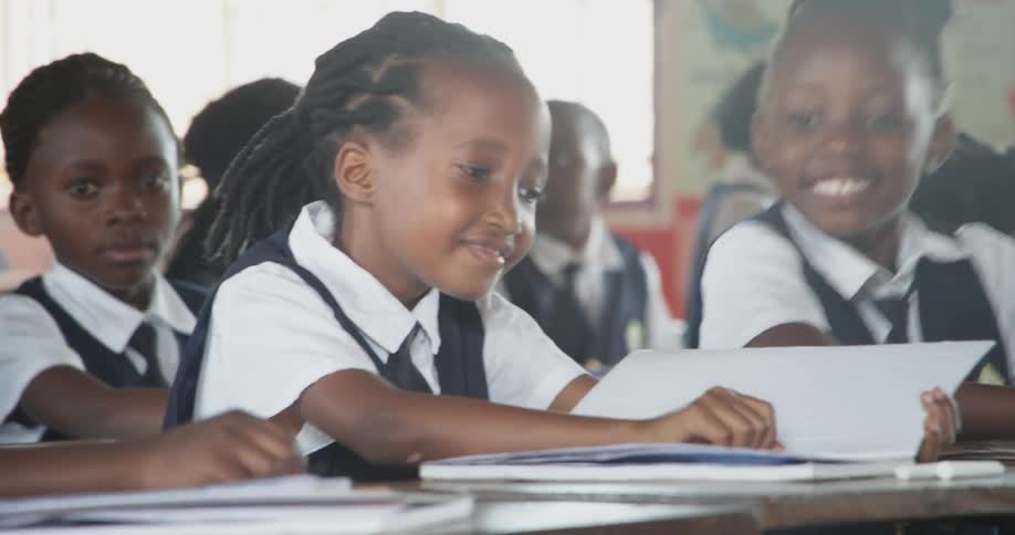 Young school children open their notebooks in class