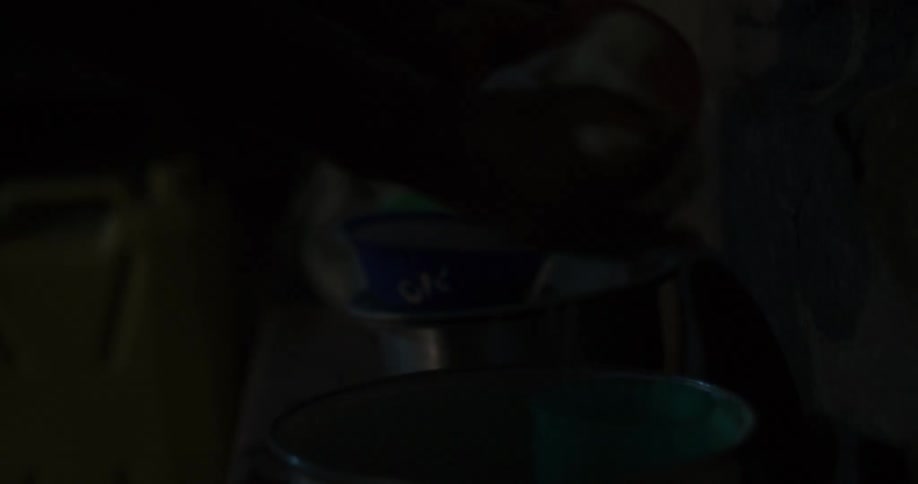 A person is washing something in the dark