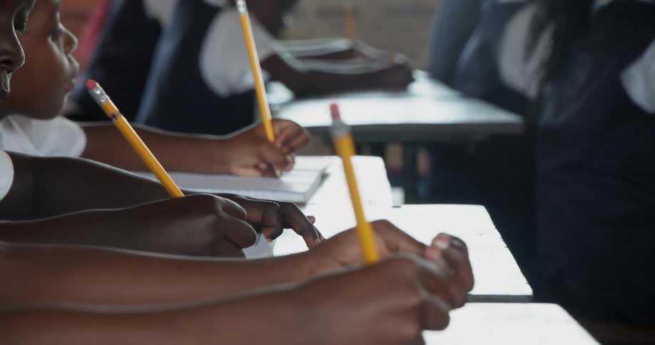 Students sit at their desks and take notes
