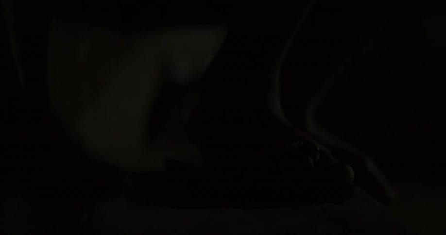 Someone puts on their sandals in the dark
