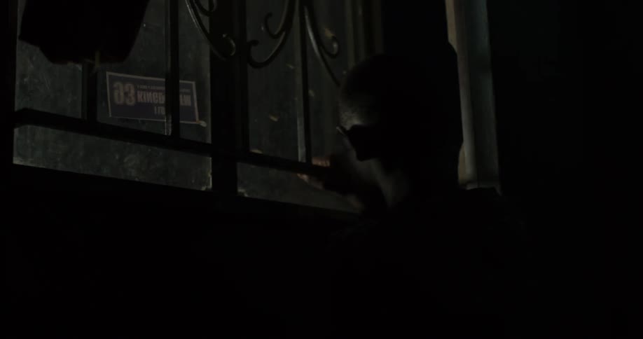 A boy walks out the door into the night