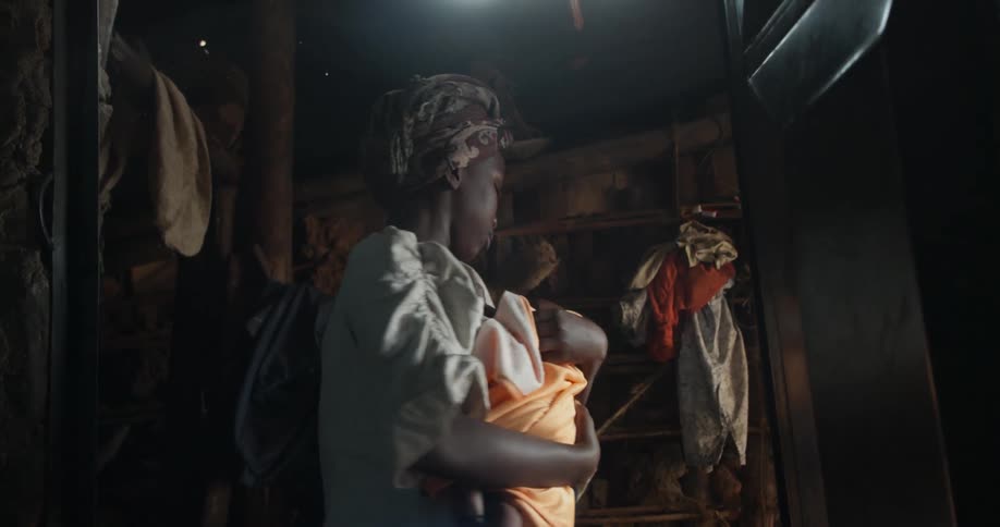A woman is in her home rocking a baby