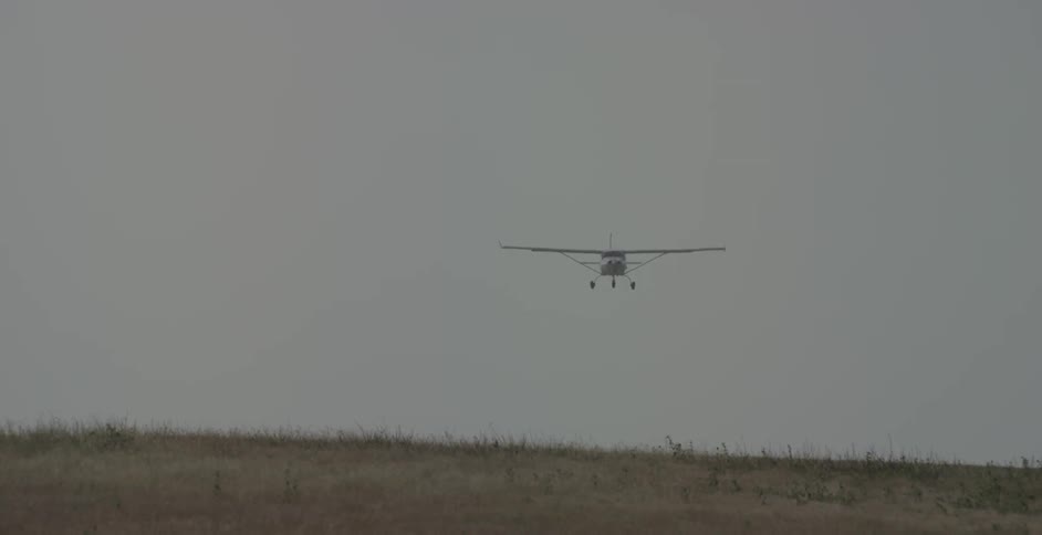 A plane is flying through the cloudy sky