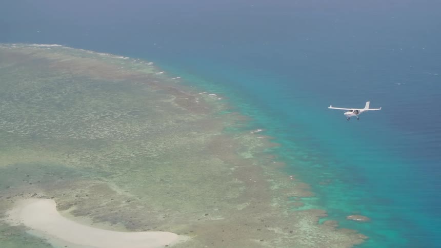 A plane is flying over a small island