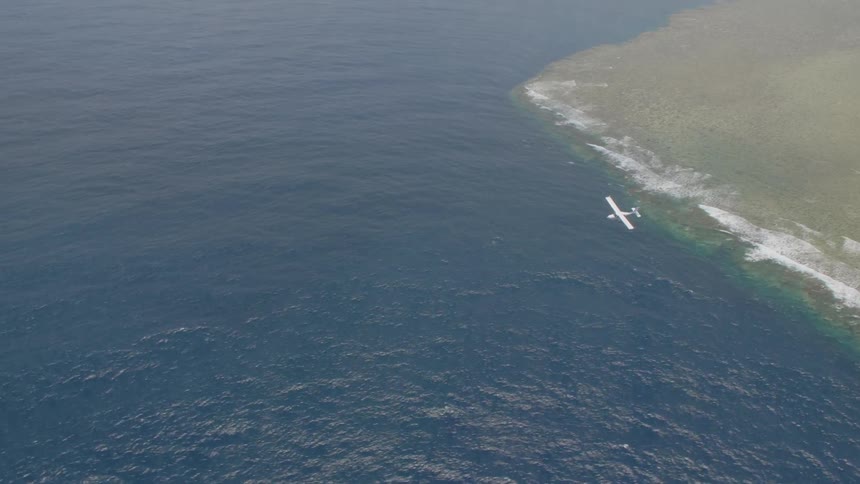Small plane flies over a large body of water