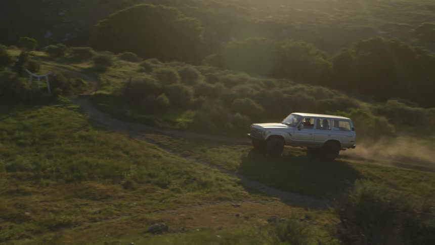 A truck drives on the dirt road uphill
