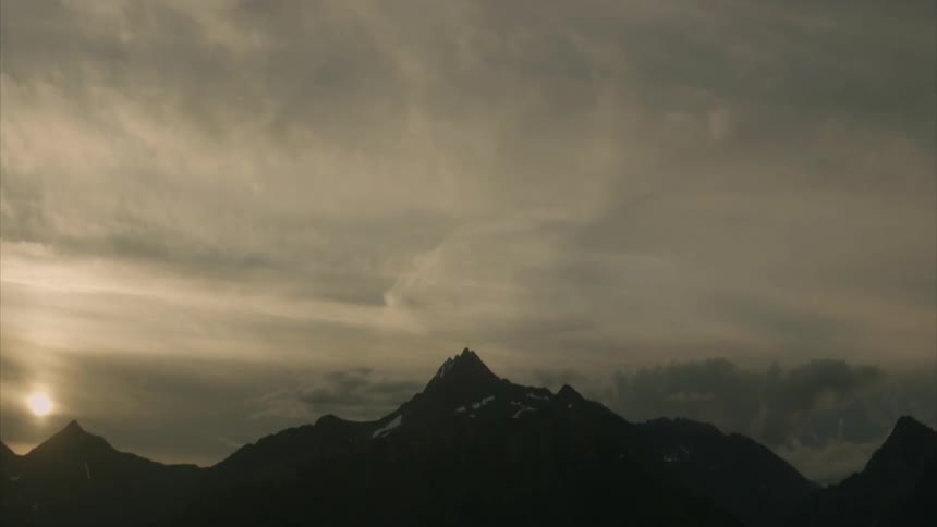 There are heavy clouds above the mountains ahead
