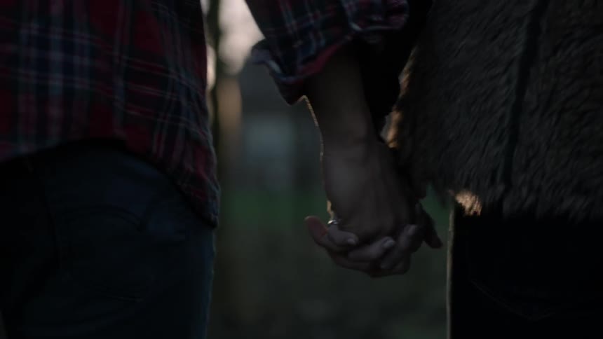 A man and woman hold hands while walking