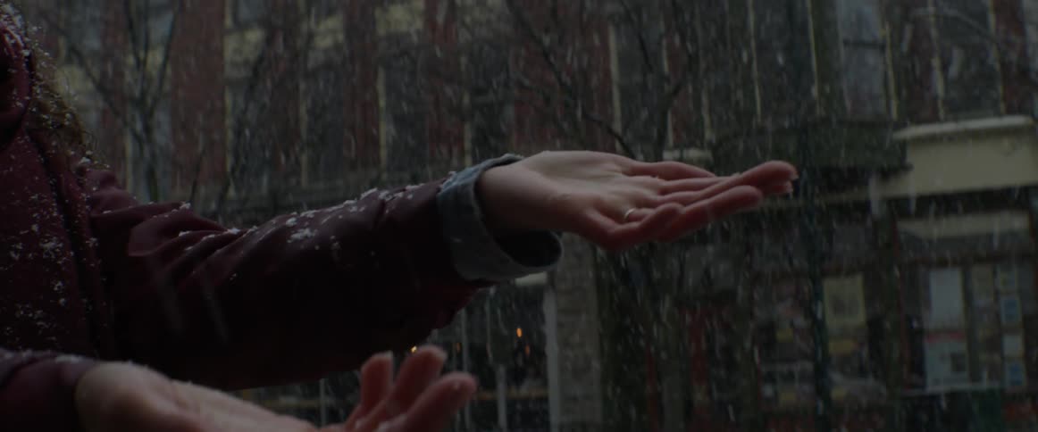 A person puts their hands out to catch snowflakes