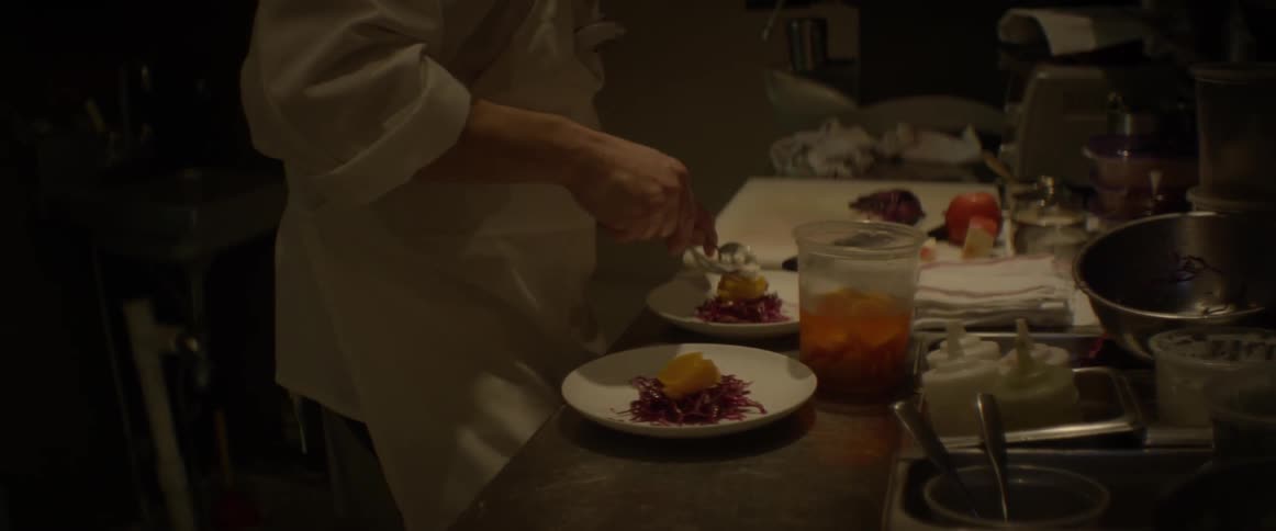 A chef scoops food onto a plate