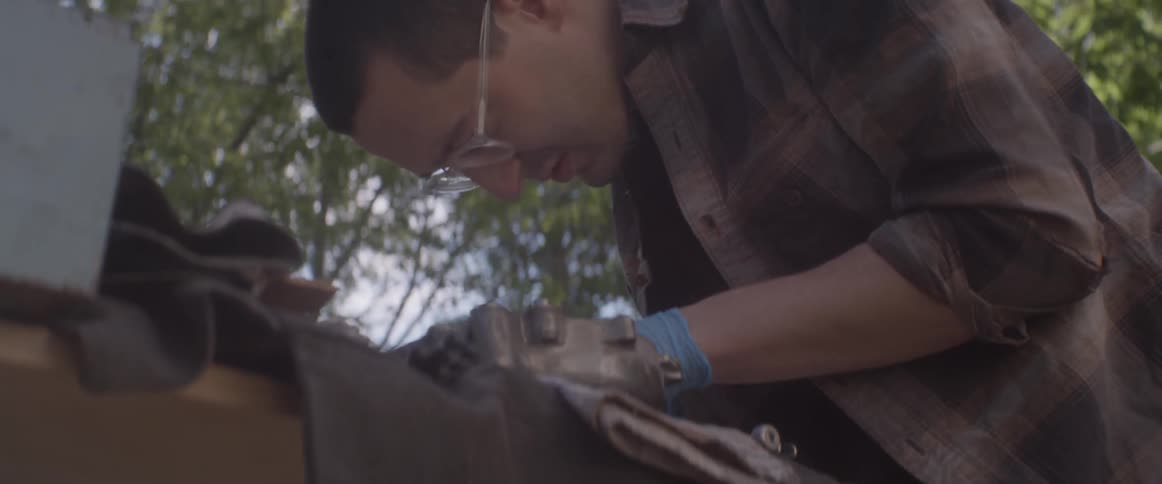 A man is working on a vehicle outside