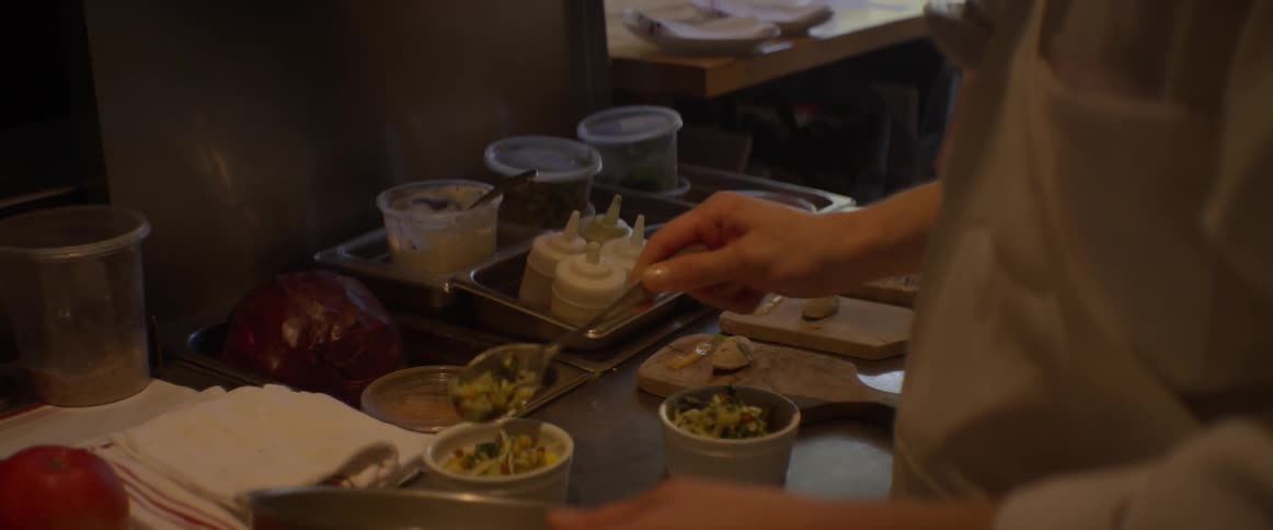 A chef puts food into a bowl