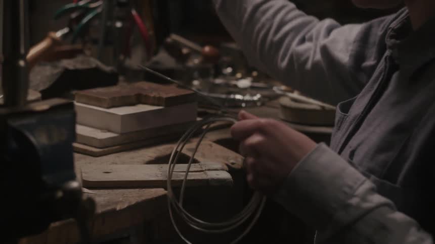 A person cuts a piece of metal in a shop