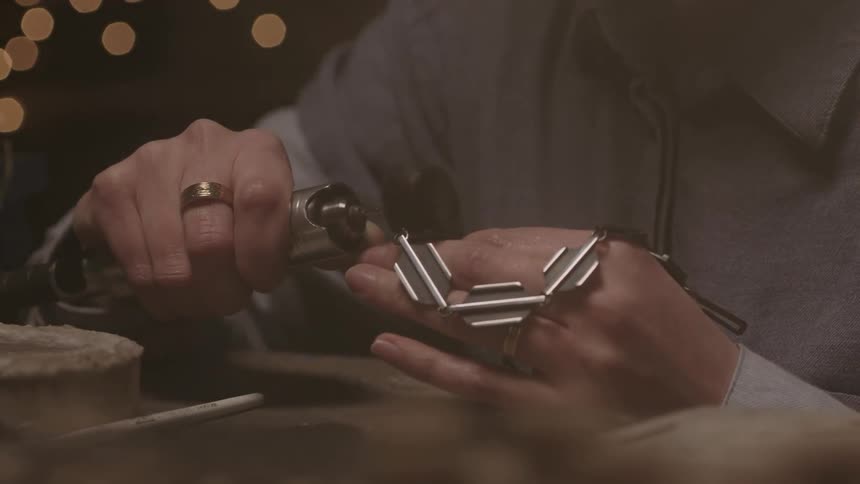 Someone is sanding a piece of metal