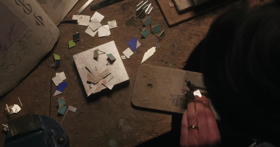 A man is using a tool to cut a piece of metal