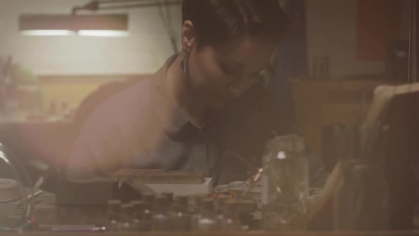 A woman is working in a shop with tools
