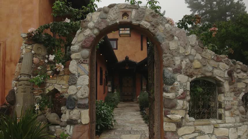 Rock archway over rock path leading to house