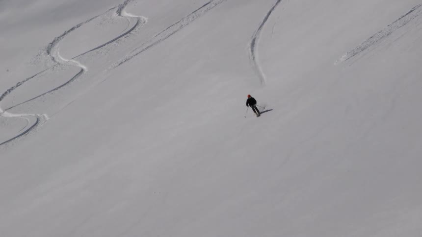A person is skiing fast down a long slope
